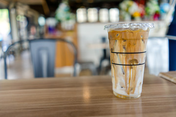 Iced coffee latte on wood table in cafe