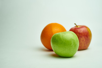 orange and red and  green apple on white background