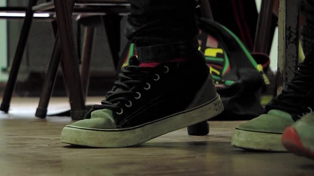 Anxious Student Tapping Feet Under Desk in High School Classroom &ndash; Close-Up