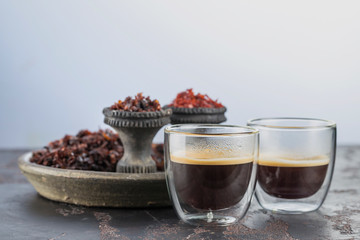 Espresso coffee in small glass cups on the background of ceramic cups for Smoking hookah filled with different types of Shisha