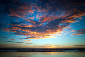 Fototapeta na wymiar sunset at the beach with colourful overcast sky