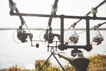 Carp fishing rods standing on special tripods. Expensive coils and a radio system of crochet