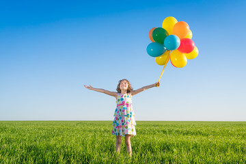 Happy child playing outdoors in spring field