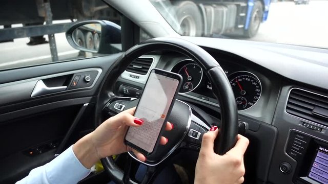 VIDEO, risk of accident concept with woman browsing smartphone while driving
