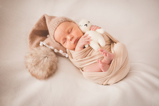 Newborn with a toy on a beige background