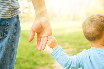 the parent holding the child's hand with a happy background