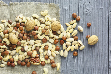 Assortment of nuts on a dark wooden table. View from above