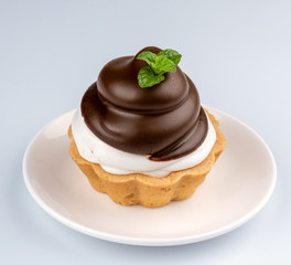 Small chocolate tarts with whipped cream on white background