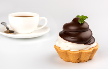 Small chocolate tarts with whipped cream and coffee on white background