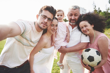 Cheerful active family having fun at countryside in summer day.