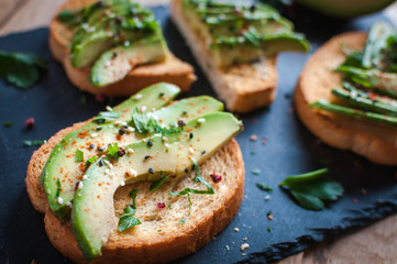 Close-up of fresh avocado toast with spices on dark background 