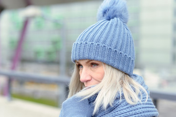 Attractive blond woman snuggling into a warm scarf