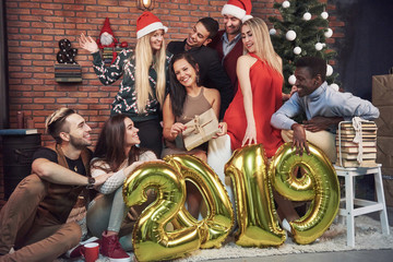 Fototapeta na wymiar Group of Cheerful old friends communicate with each other. New 2019 Year is coming. Celebrate the new year in a cozy home atmosphere