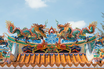 Double golden dragon statue on blue sky background