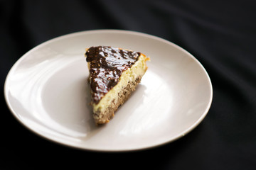 Piece of chocolate cheesecake on black background