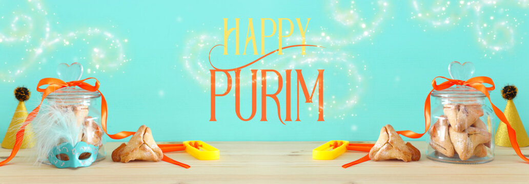 Purim celebration concept (jewish carnival holiday) over wooden table and mint background.
