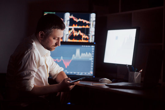 Using modern technologies at work. Young businessman working on digital tablet while sitting at the desk in creative office
