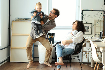 Naklejka premium Happy young family laughing and dancing at home