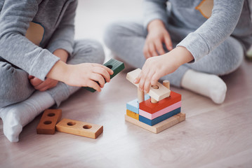 Children play with a toy designer on the floor of the children's room. Two kids playing with...