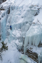 Ice climbing the North Greece, man climbing frozen waterfall.