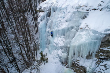 Ice climbing the North Greece, man climbing frozen waterfall.