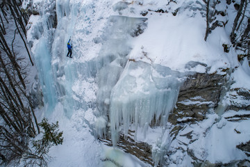 Ice climbing the North Greece, man climbing frozen waterfall.