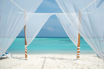 Fototapeta na wymiar White tent for wedding ceremonies or romantic evening on a maldivian island.