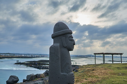 The harubang sculture at a park near the ocean of Jeju Island, South Korea.