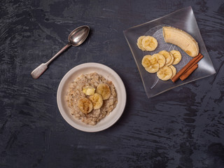 Healthy breakfast of oatmeal, sprinkled with cinnamon and banana slices.