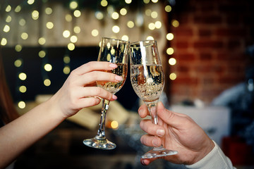 Two glasses of champagne in the hands of a couple in love.