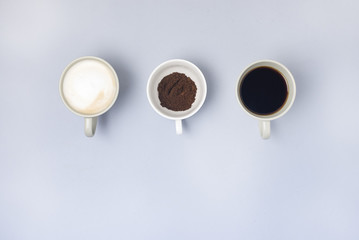 Coffee Cup Assortment Cup of Espresso Cup of Cappuchino Cup with Ground Coffee Top View Blue Background