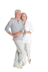 Portrait of senior couple hugging on white background, full length