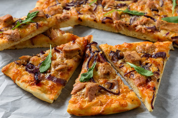 Homemade tuna and mozzarella pizza on wooden background.