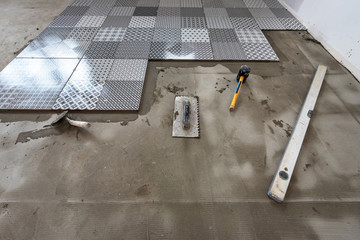 Ceramic tiles and tools for tiler. Floor tiles installation.