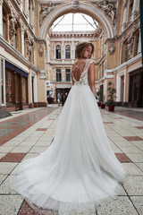 Obraz premium Beautiful, elegant bride with a perfect wedding dress, poses around beautiful architecture.