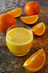 Sliced oranges and orange juice on the table. dark background.