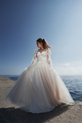 Fototapeta na wymiar bride in a wedding dress on the beach near the sea