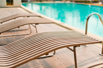 wooden outdoor bench near swimimg pool relax vacation background concept