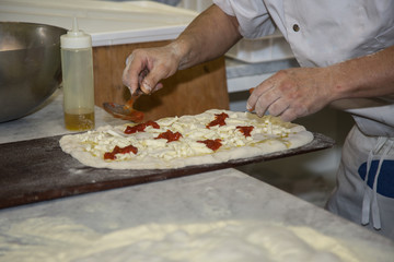 Obraz na płótnie Canvas Processing of the Pizza Dough by the Pizza Maker