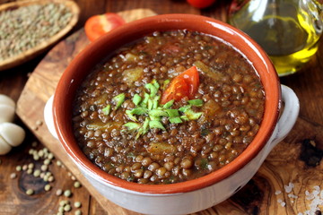 Delicious lentils soup on wooden background. Top view with copy space. Diet food. Vegetarian and vegan food.