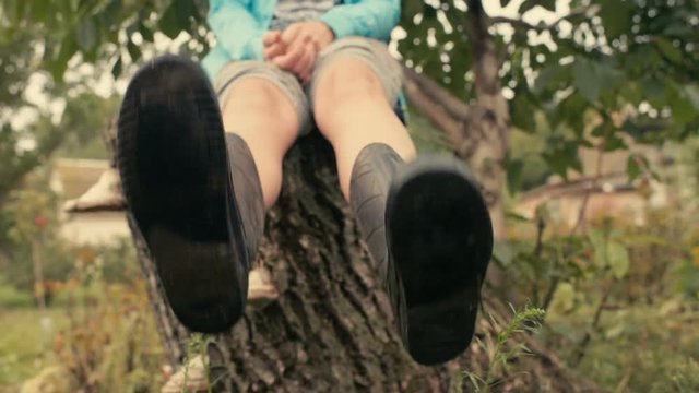 feet in rubber boots with dirt on the sole of a close-up