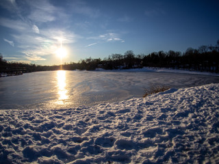 wide angle view of frozen lake in winter end of afternoon