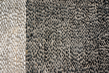 Detail of black and white stones on cement in Oia, Santorini