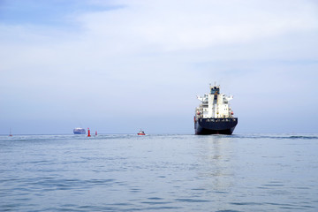 Fototapeta premium Big cargo ship loaded with many shipping containers