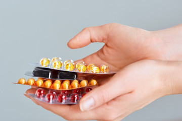 Vitamins And Supplements. Closeup Of Woman Hands Holding Variety Of Colorful Vitamin Pills. Close-up Handful Of Medication, Medicine Tablets, Capsules. Healthy Diet Nutrition Concept.