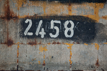rust and paint texture on a concrete wall with a number