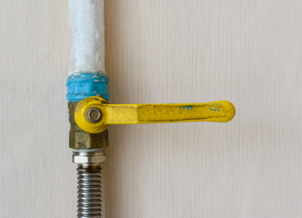 old ball valve with a yellow handle to shut off the flow of gas. pipe and hose connection. gas pipeline. ball valve.