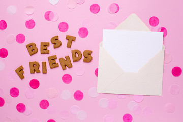 Letters cookies Best Friends with card and confetti on pink background