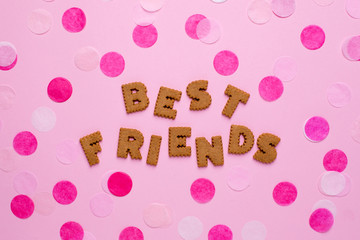 Letters cookies Best friends with confetti on pink background