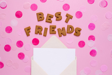 Letters cookies Best Friends with card and confetti on pink background